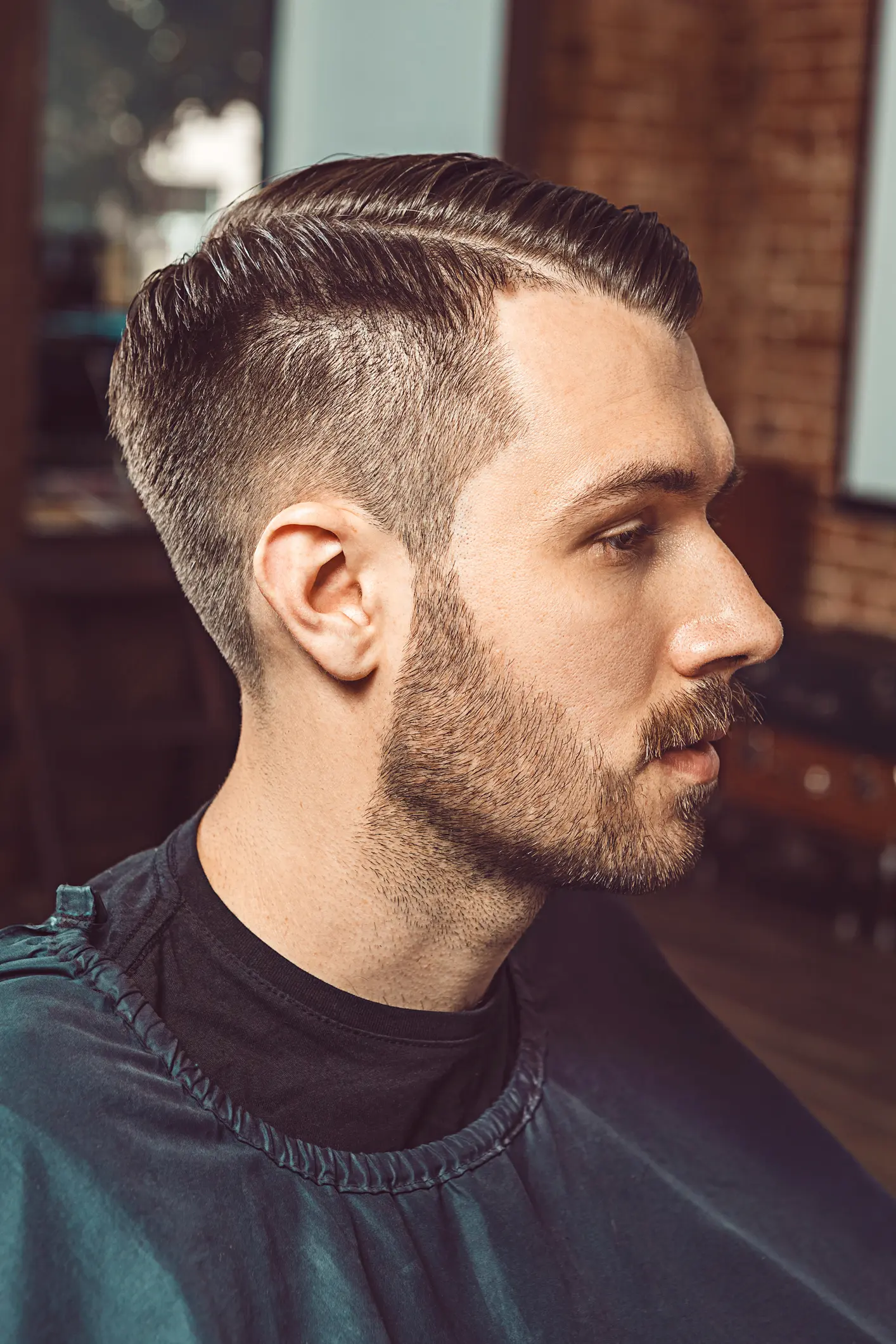 Profile of a man with a styled haircut and beard.